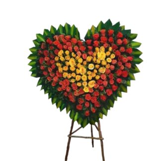 Corazón fúnebre con rosas salmón y amarillas para homenaje floral elegante