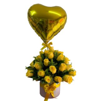 Arreglo redondo con rosas amarillas y globo metálico en forma de corazón.
