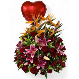 Arreglo triángulo con aves de paraíso, rosas rojas, lirios y globo metalizado.