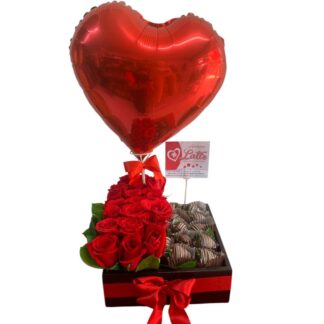 Cubo de rosas rojas con fresas cubiertas de chocolate y globo metalizado.