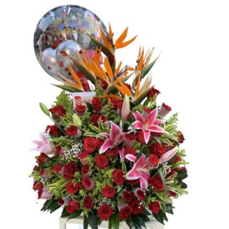 Triángulo de rosas rojas y lirios con globo burbuja.
