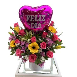 Arreglo media luna de rosas fucsias y gerberas con globo metalizado.