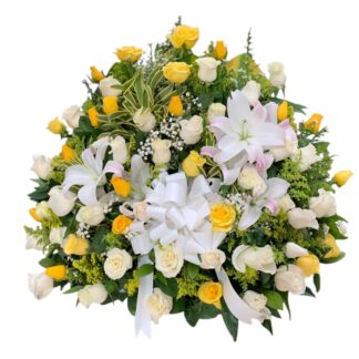 Arreglo en abanico de rosas amarillas y blancas con lirios amarillos y perlas.