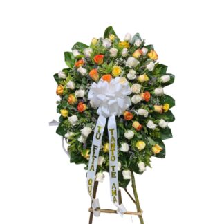 Corona fúnebre de rosas amarillas y blancas.