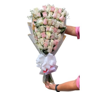 Detalle de rosas blancas y rosadas con decoración en perla.