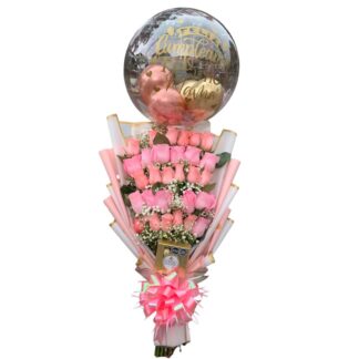 Detalle de rosas rosadas con chocolates y globo burbuja.