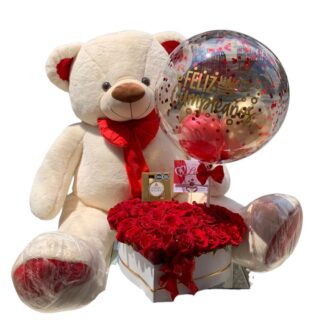 Oso blanco con corazón de rosas rojas, chocolates y globo burbuja.